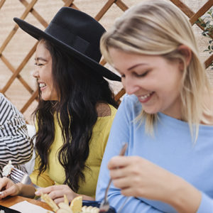 Young multiracial friends having breakfast outdoors in restaurant - Focus on asian girl face